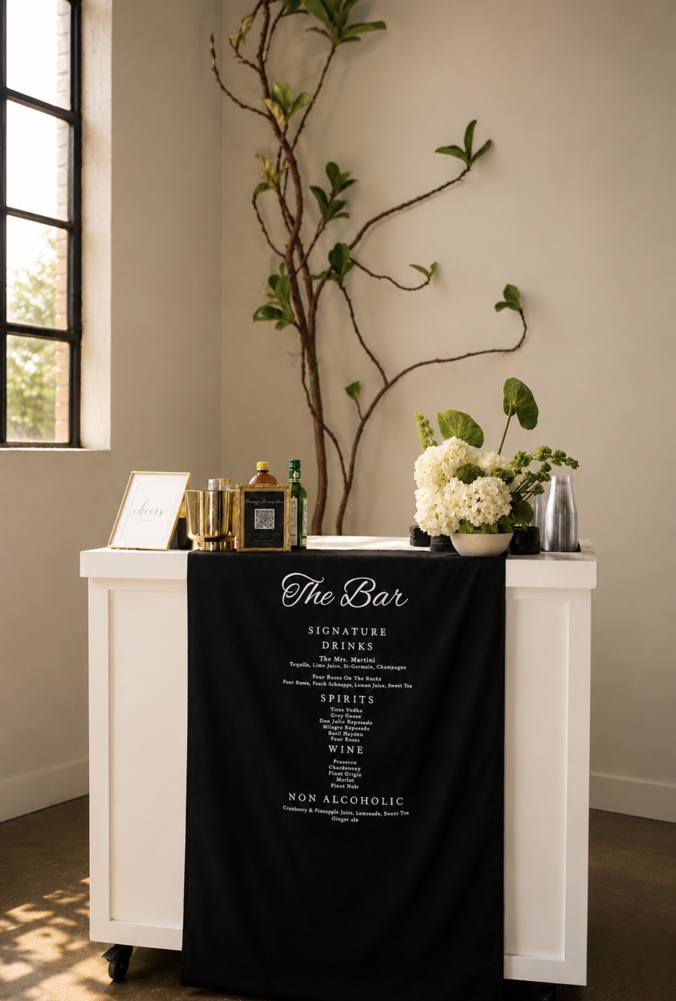 Custom wedding bar styling with black linen and floral arrangements