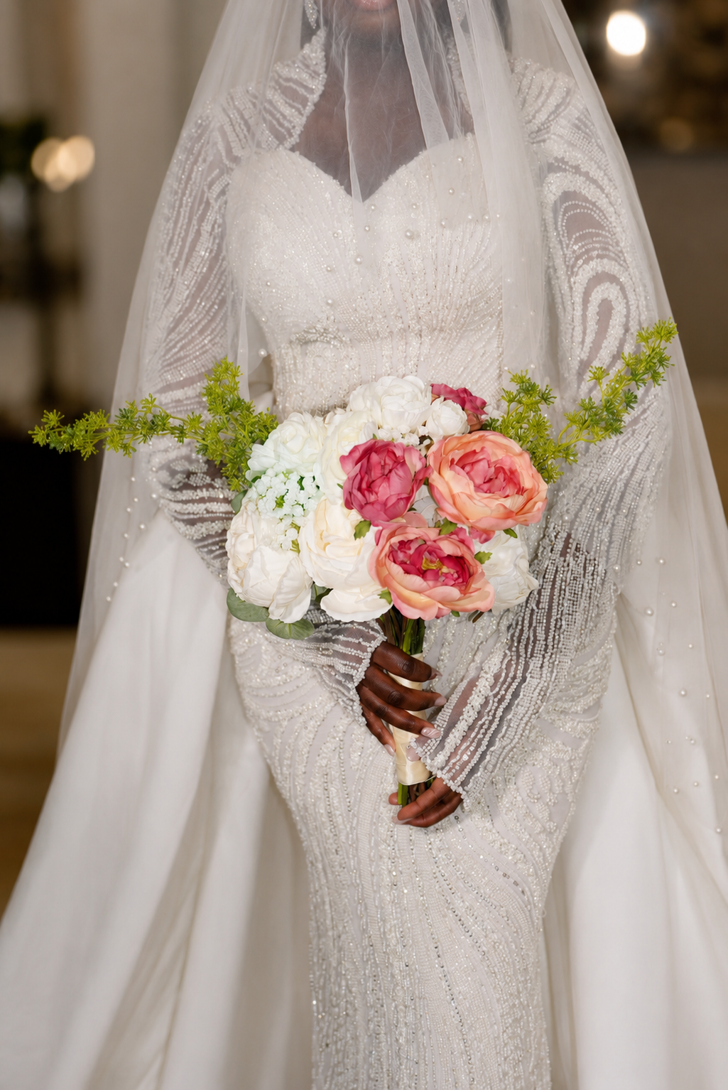 Bride in beaded gown holding bouquet